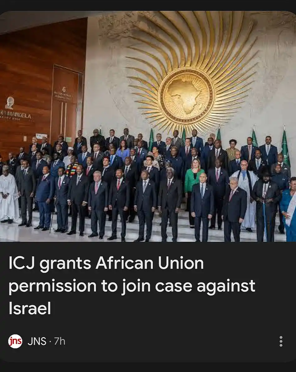 A formal group photo of numerous African Union leaders in suits standing before a large golden emblem of Africa on a wall…