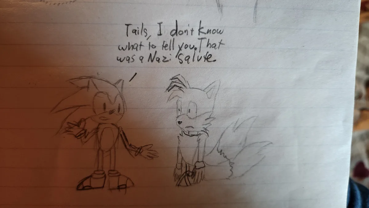 A hand-drawn sketch on lined paper shows Sonic the Hedgehog gesturing with his right hand raised in a salute while speaking…