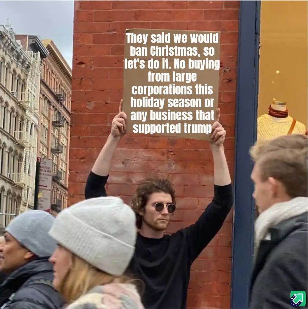 A person with curly hair and sunglasses holds up a cardboard sign in a city street with brick buildings. The sign reads…