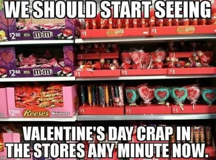 A grocery store shelf filled with Valentine's Day candy, including M&M's, Reese's Minis, and heart-shaped lollipops, all…