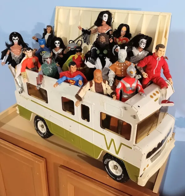 A white and green toy bus, labeled 'Indian' and featuring a large 'W' on its side, is overflowing with dozens of action…