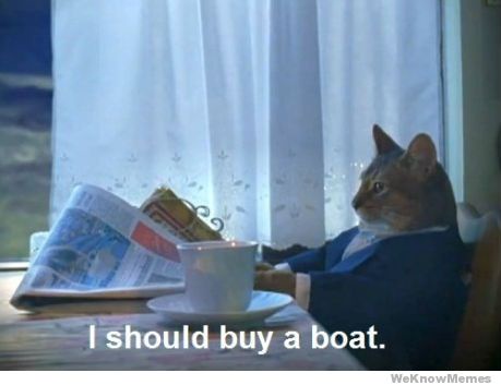 A cat wearing a dark suit and white shirt sits at a table by a window, looking out thoughtfully. In front of it is a…