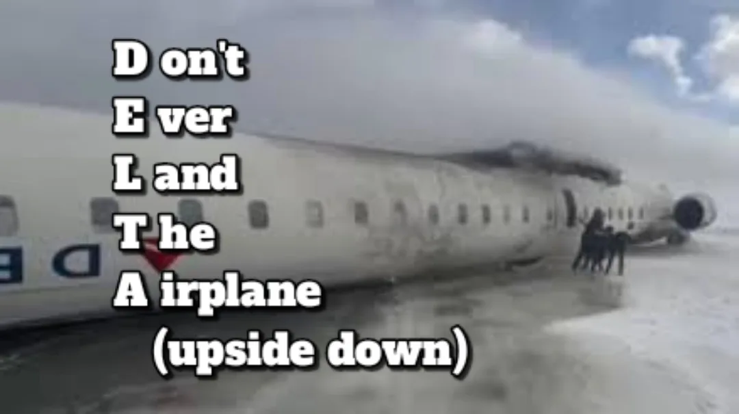 A damaged airplane lies upside down in a snowy field, with smoke rising from its fuselage and several figures standing near…
