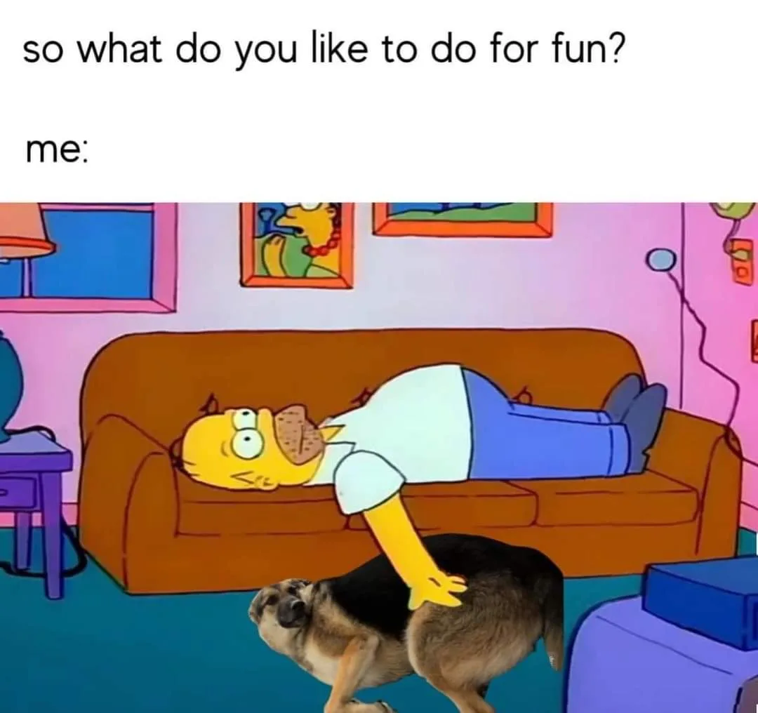 The image shows Homer Simpson lying on his back on a brown couch in his living room, with his right arm extended and resting…