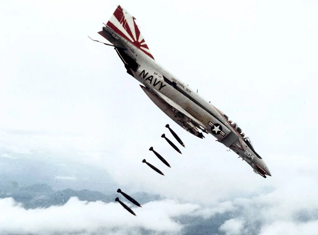 A U.S. Navy F-4 Phantom II fighter jet, marked with 'NAVY', 'VF-11', 'USS CORAL SEA', and the number '204', is shown in a…