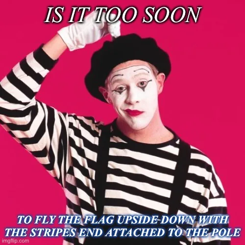 A man dressed as a mime in a black and white striped shirt, black beret, and white gloves, with white face paint, red lips…