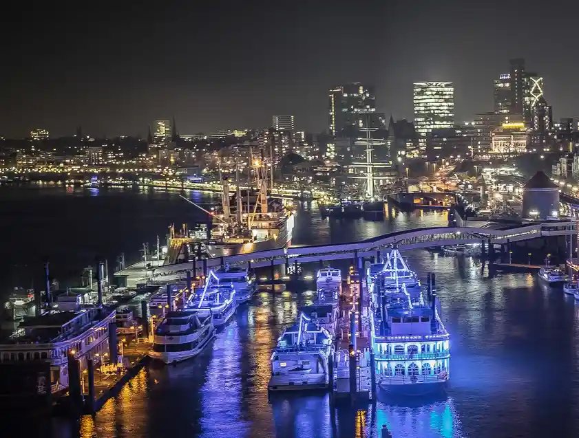 A nighttime city harbor scene with illuminated boats and a skyline, overlaid with the text 'i'm not lazy, i'm just…