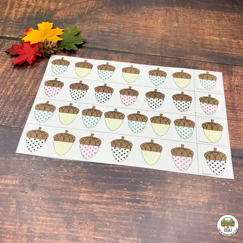 A sheet of printable acorn stickers with brown caps and patterned shells in polka dots and stripes, arranged in rows on…