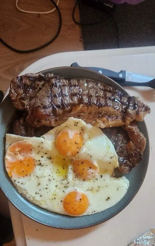 A close-up photo shows a dark skillet containing a large, grilled steak with visible char marks, alongside four…