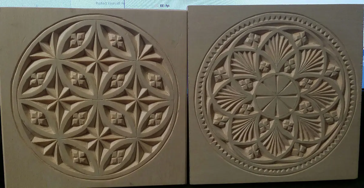 Two intricately carved wooden circular panels with symmetrical geometric patterns sit side by side. The left panel features…