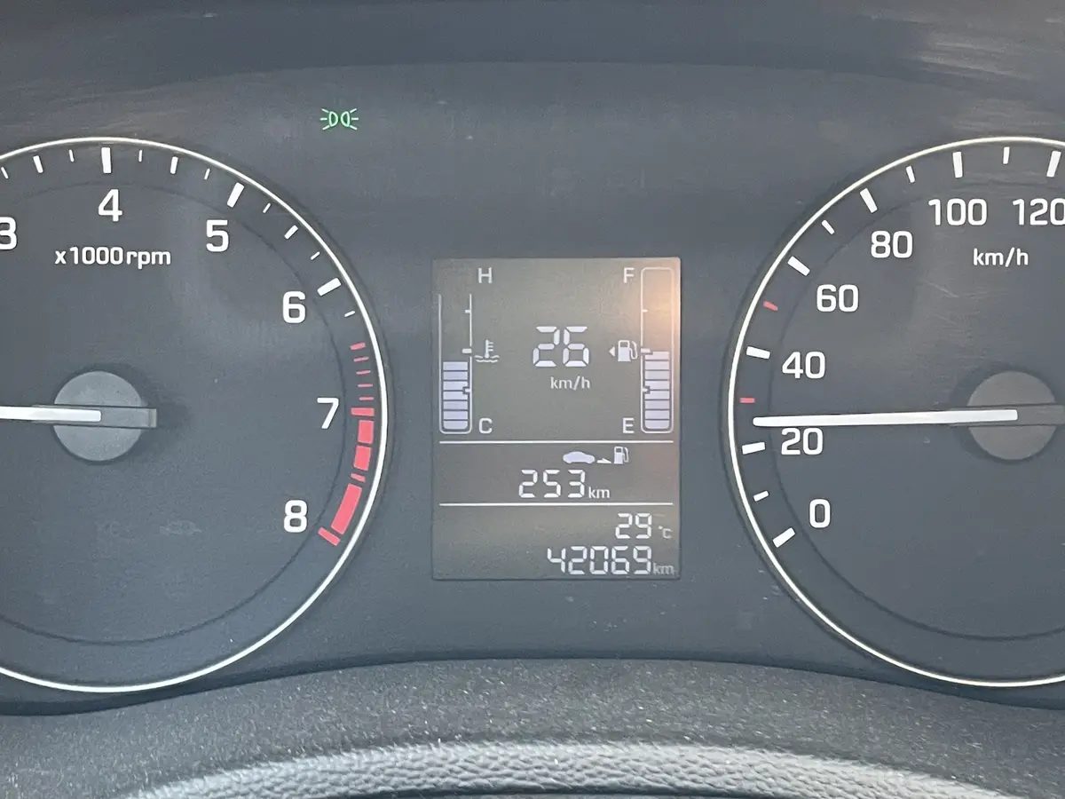 A close-up of a car's dashboard showing a speedometer at 26 km/h, tachometer at idle, and a digital display indicating 42069…