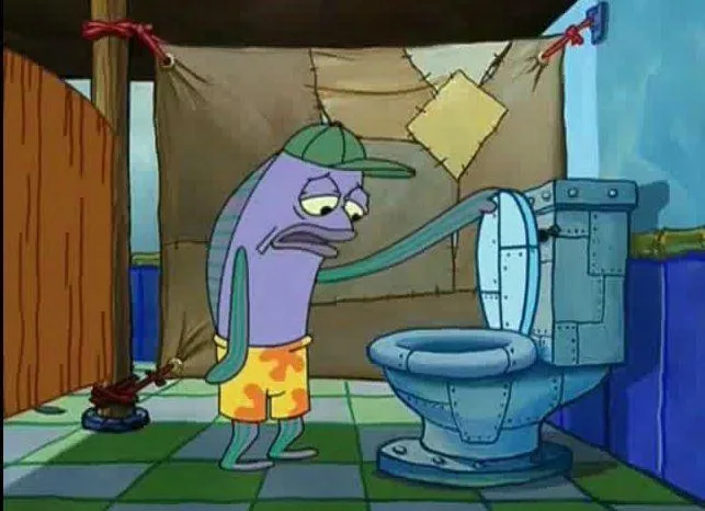 A purple, fish-like cartoon character wearing a green cap and orange shorts stands in a bathroom with a checkered floor…