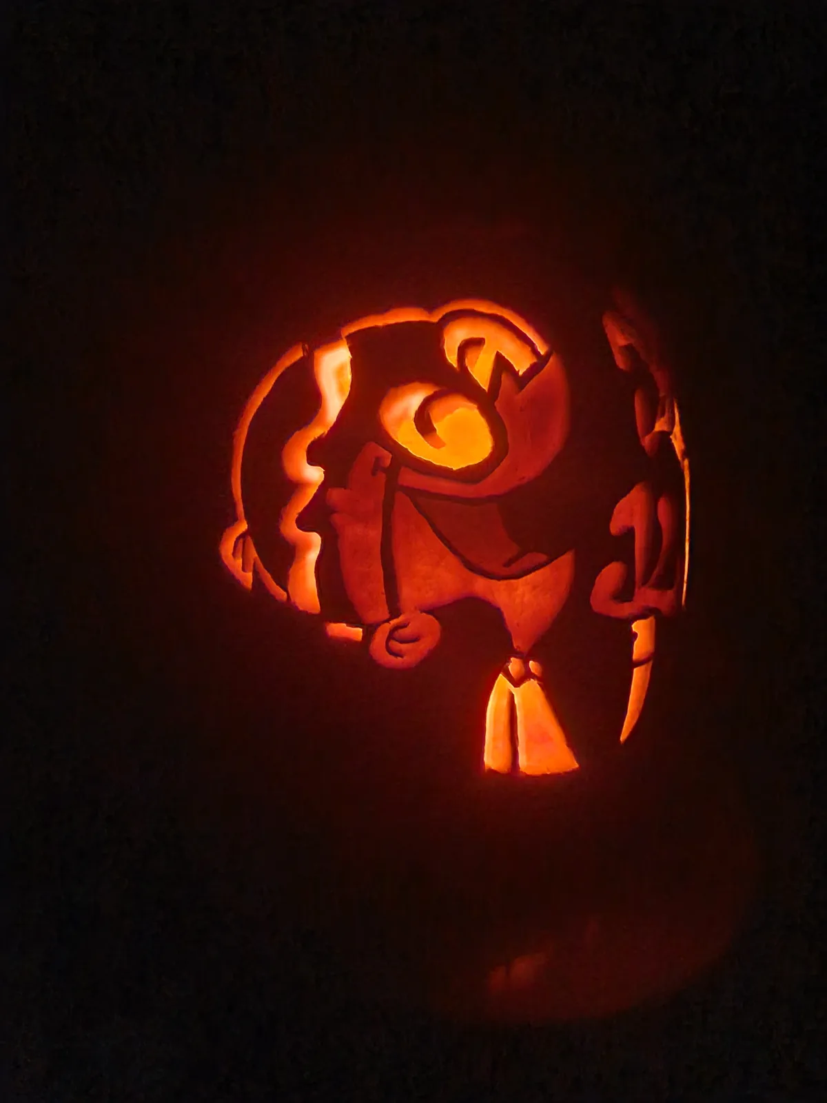A carved pumpkin illuminated from within, depicting the character from 'The Legend of Zelda: Breath of the Wild' with a…