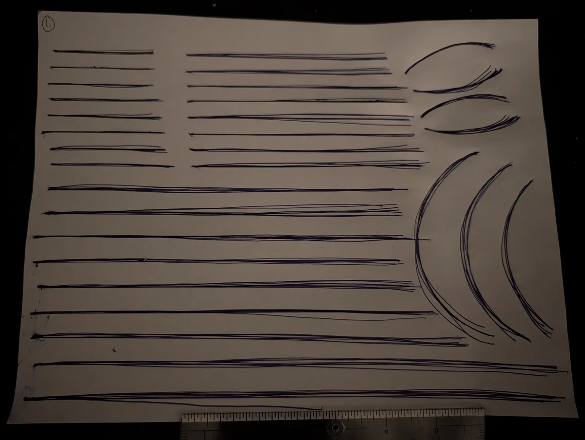 A white sheet of paper displays numerous dark blue ink lines drawn with a pen, mostly horizontal and varying in…