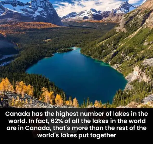 A scenic photograph of a deep blue alpine lake nestled in a valley surrounded by snow-capped mountains and forests with…