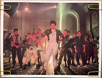 A still from the movie 'Aliens' shows a group of soldiers in futuristic gear standing in a sci-fi corridor, with one man in…