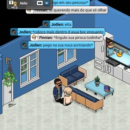 A screenshot from the game 'The Sims' shows two characters in a living room, one kneeling before the other. Overlaid chat…