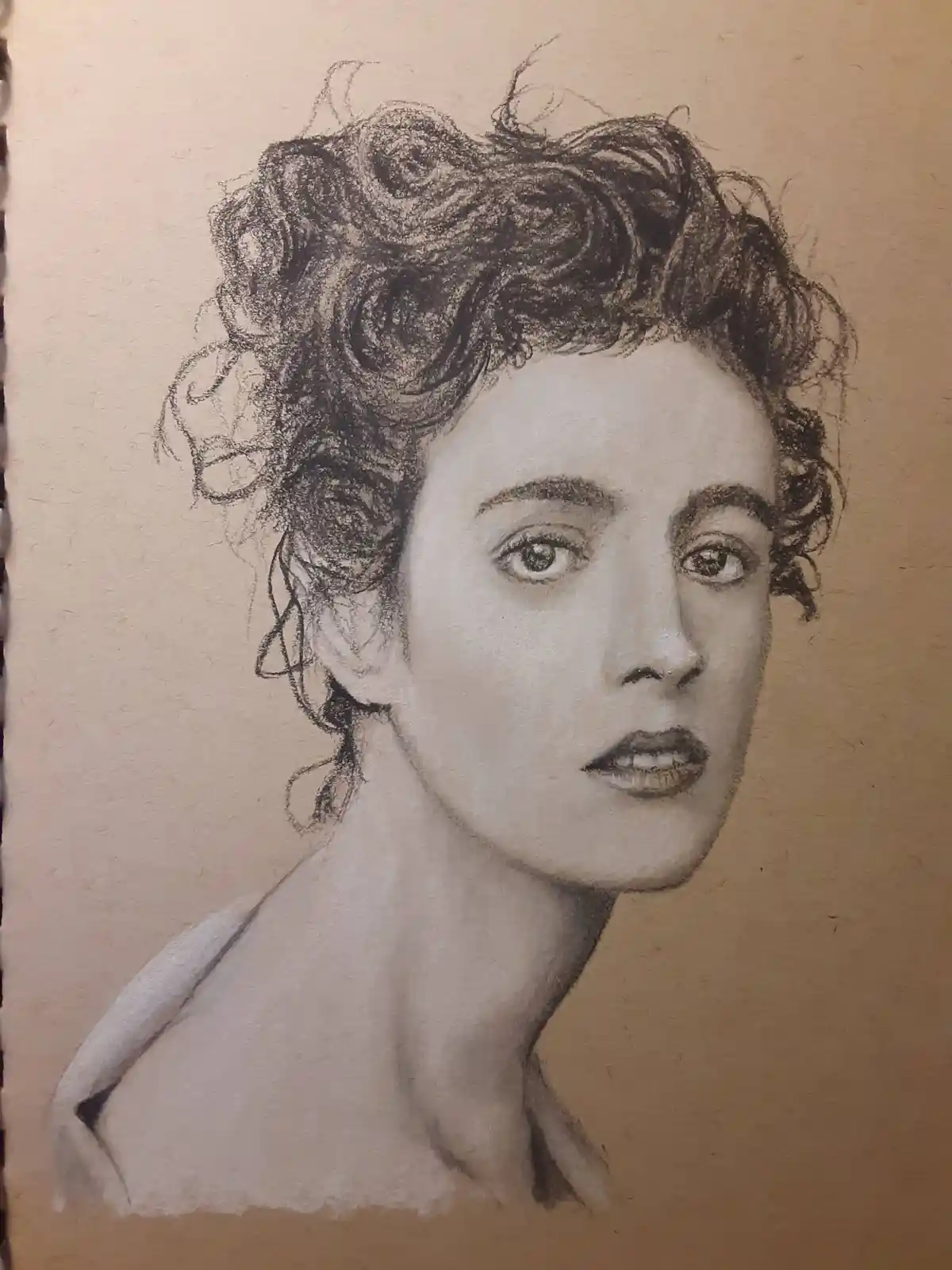 A detailed pencil sketch on textured beige paper depicts a woman with curly dark hair, looking slightly upward with a…