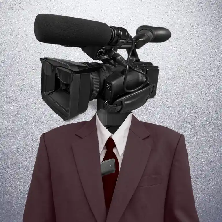 A person in a maroon suit, white shirt, and red tie has a professional video camera mounted where their head should be…