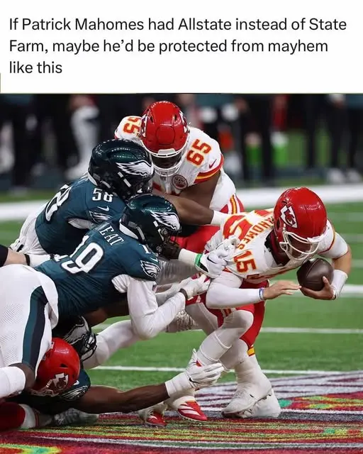A football player in a red and white uniform, identified as Patrick Mahomes by the number 15 on his jersey, is being tackled…