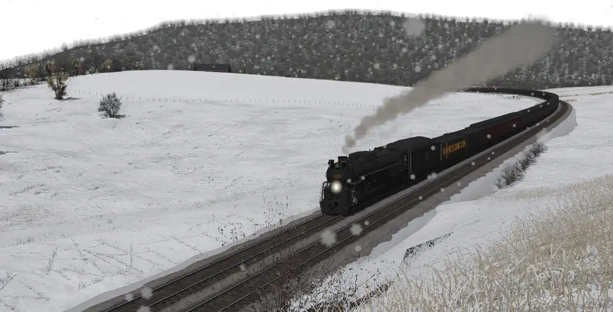 A black steam locomotive pulls a long train through a snowy, rural landscape with hills and sparse trees under a gray sky…