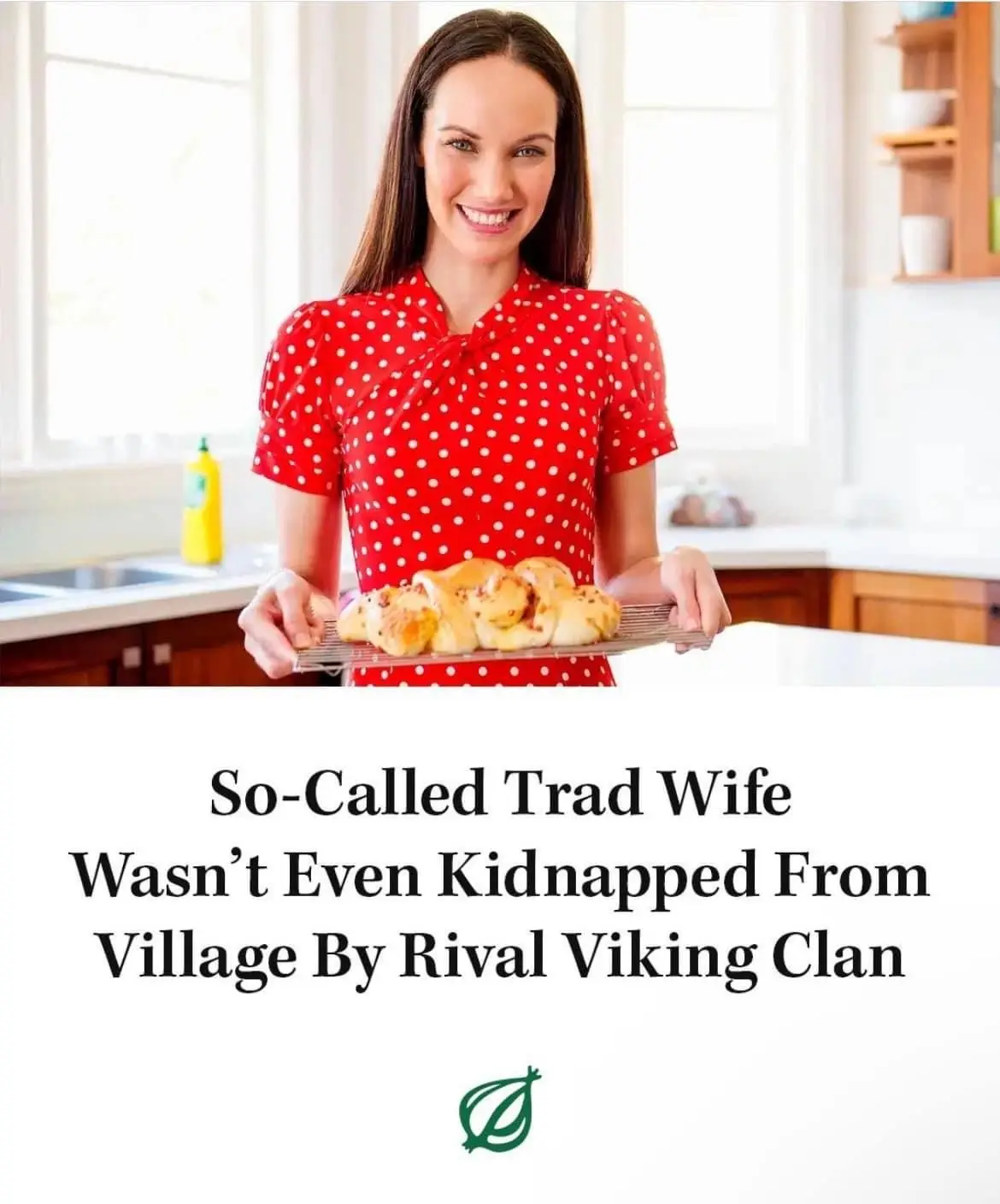 A woman in a red polka-dot dress smiles while holding a tray of baked goods in a bright kitchen. The overlaid text reads…