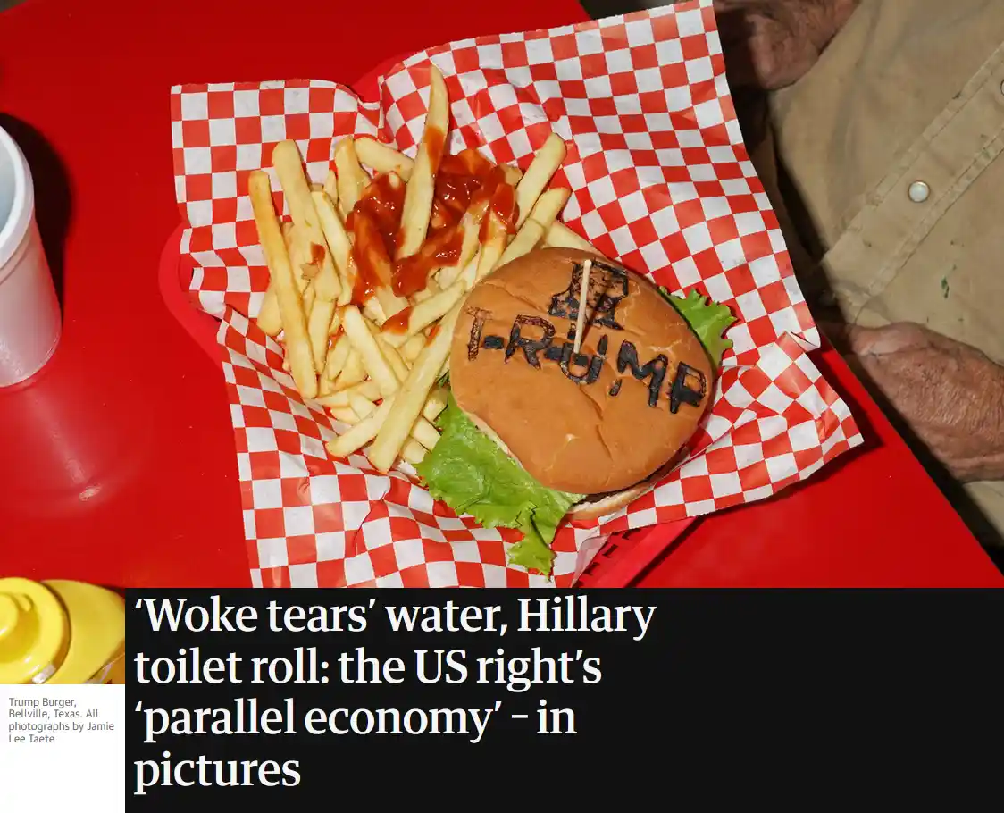 A close-up photo shows a burger with 'T-RUMP' written on the top bun using a toothpick and dark sauce, served with fries on…