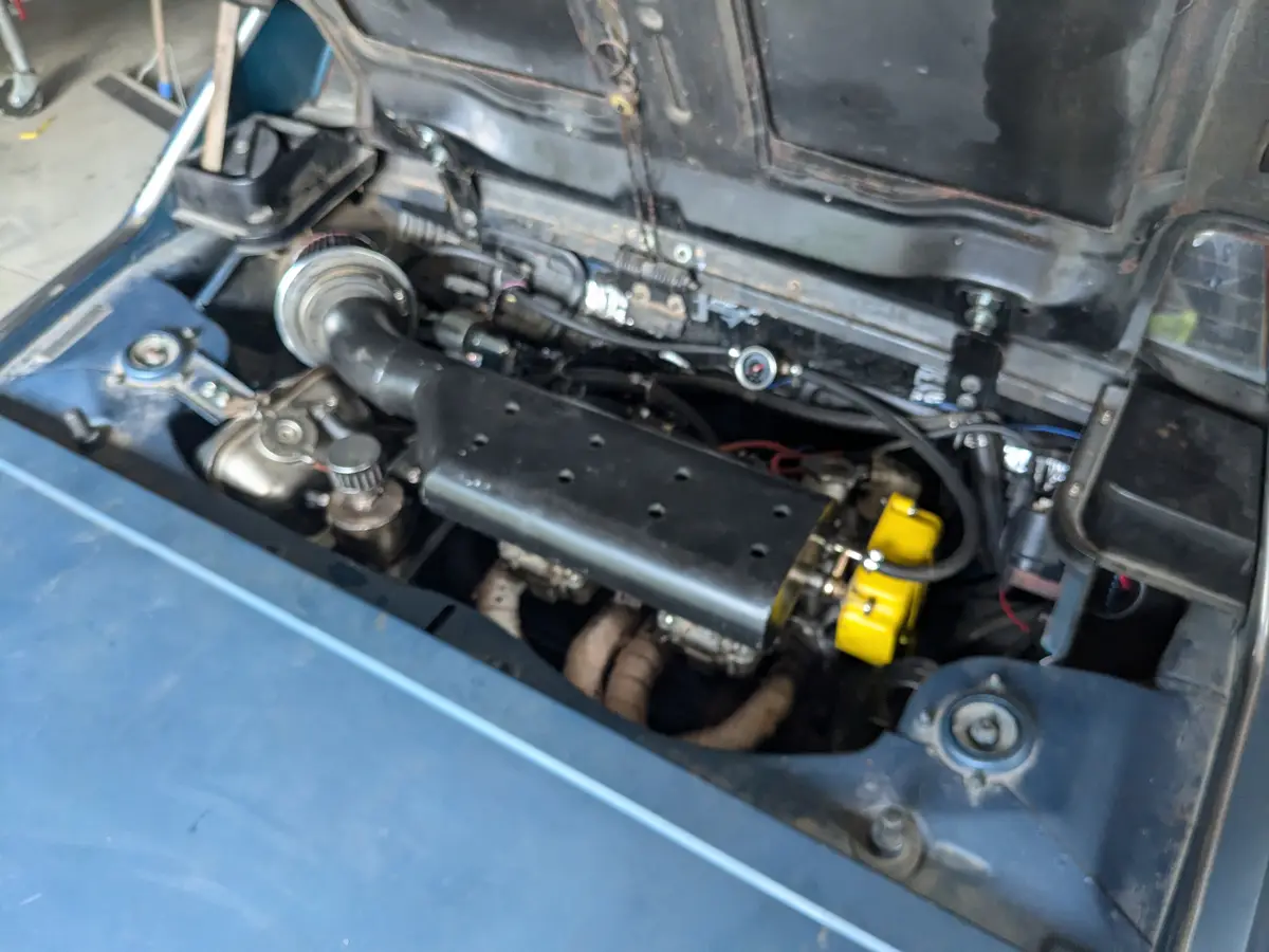 A close-up photo of a car's engine bay with various mechanical parts visible, including a prominent yellow component and a…