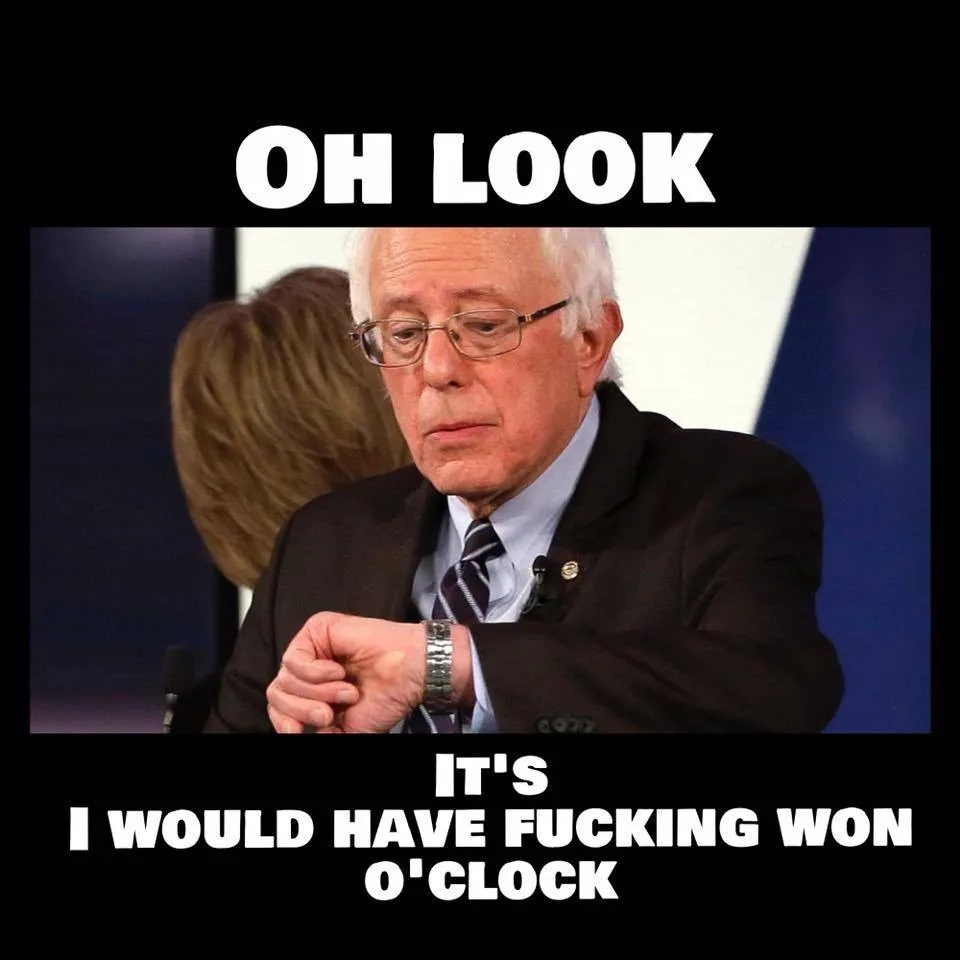 A photo of Bernie Sanders looking down at his wristwatch with a resigned or annoyed expression. The image has white bold…
