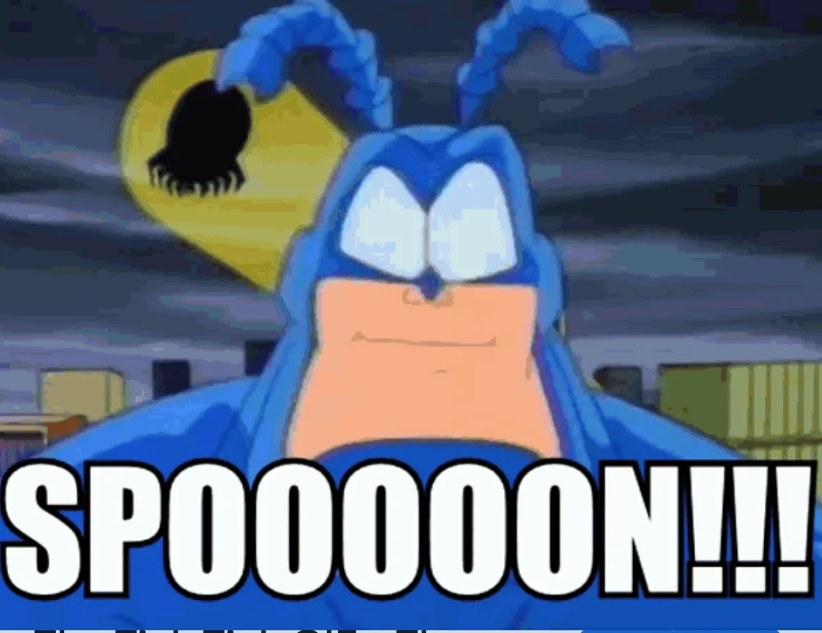 A blue cartoon character with large white eyes and antennae, wearing a blue cape, stares intensely at the viewer with a…