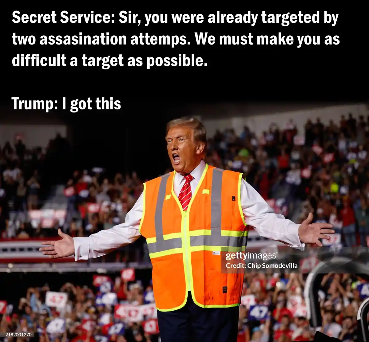 A man wearing an orange safety vest over a white shirt and red tie stands with arms outstretched in front of a crowd. The…