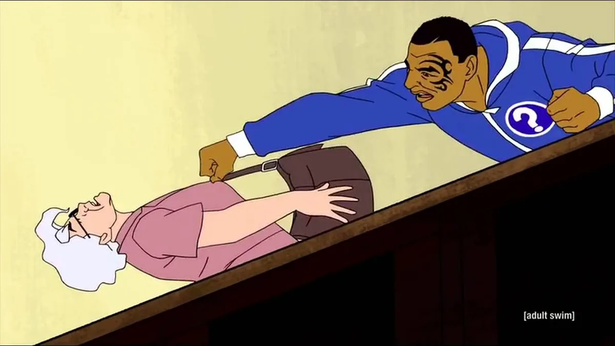 An animated scene from 'The Venture Bros.' shows a muscular man in a blue superhero costume with a question mark emblem…