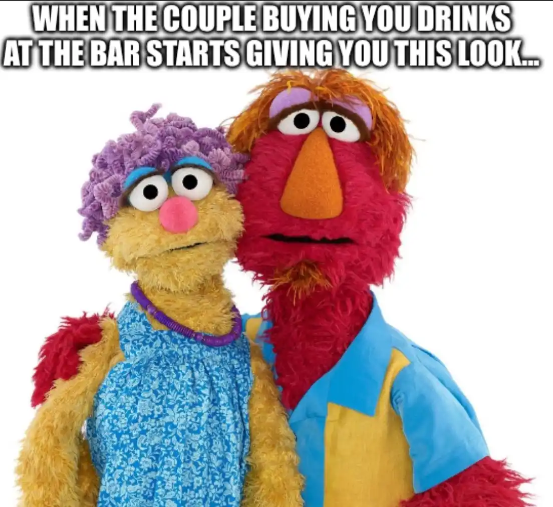 Two Muppet characters, a female with purple curly hair and a blue dress, and a male with red fur and a blue-yellow shirt…