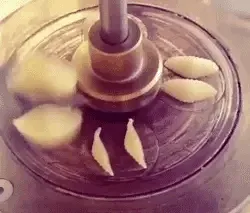 A six-panel image sequence shows a food processor with a central blade spinning, causing small shell-shaped pasta pieces to…