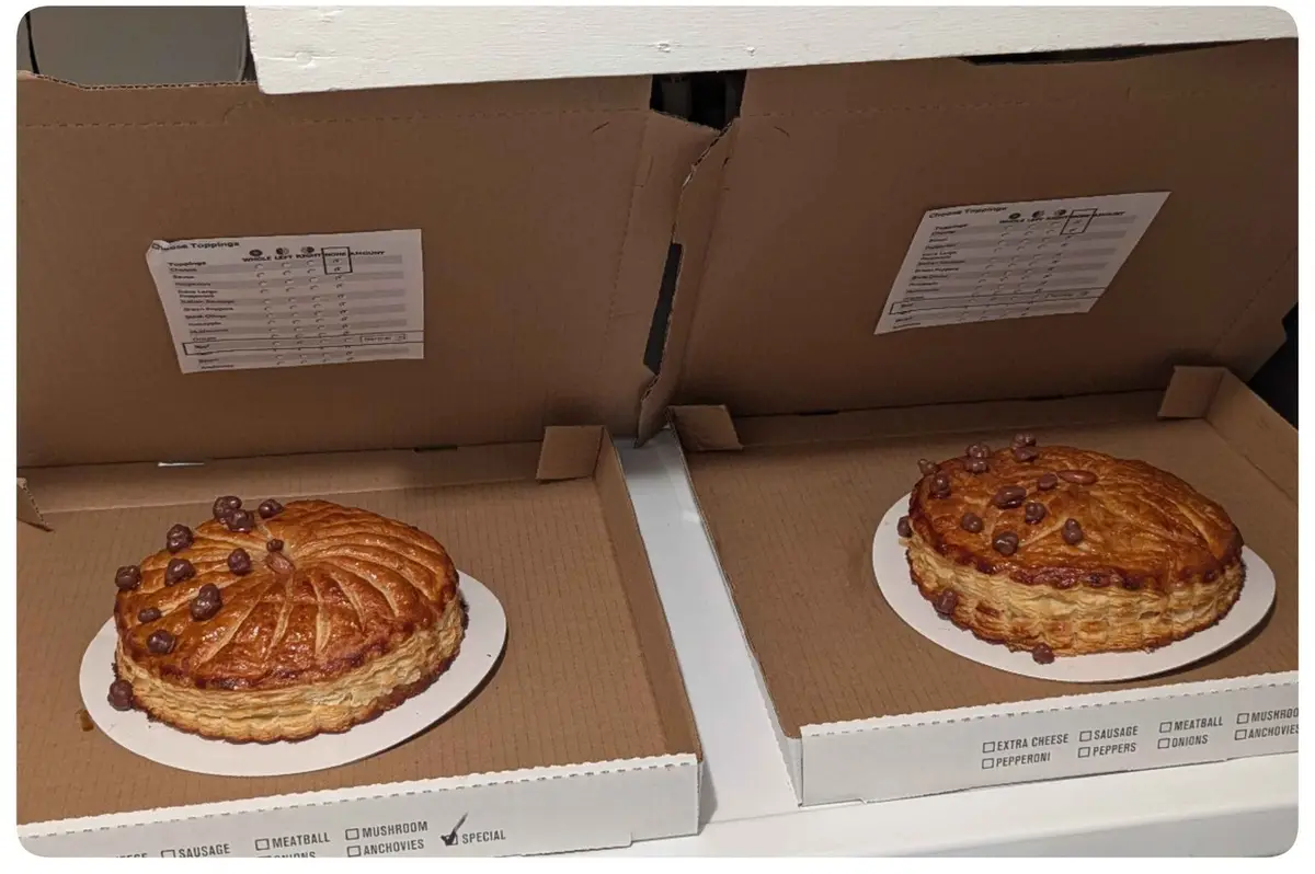 Two identical-looking savory pies in pizza boxes, each with a 'Choose Toppings' form inside. The forms show checkboxes for…