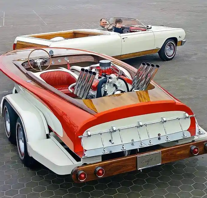 A vintage-style car with a wooden interior and exposed engine with chrome exhaust pipes is parked in a lot, with a man and a…