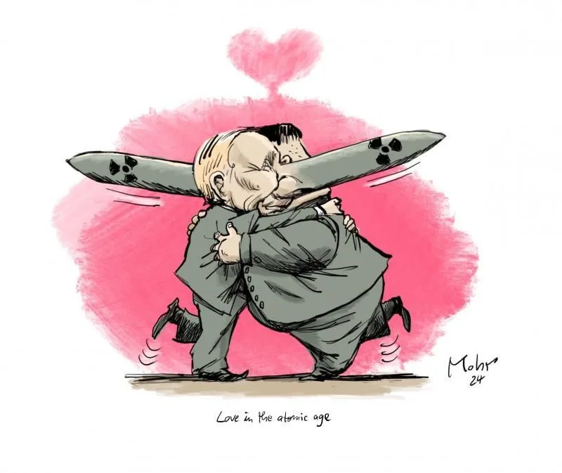 Two cartoon men in suits are passionately kissing while holding a large nuclear missile horizontally between them, with a…