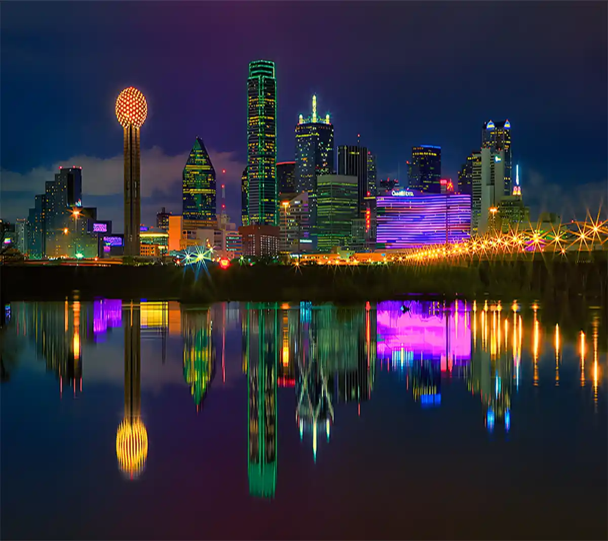 A vibrant nighttime cityscape of Dallas, Texas, featuring the iconic Reunion Tower with its glowing sphere, colorful…
