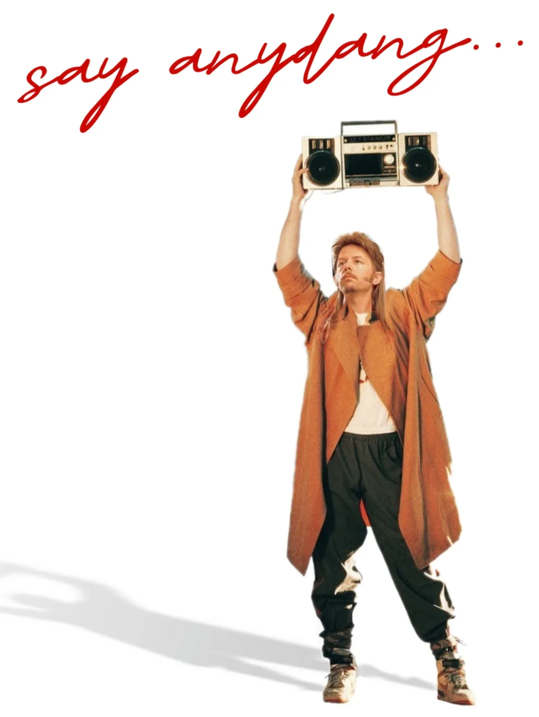 A man in an orange coat and black pants holds a beige boombox above his head with both hands against a white background. Red…