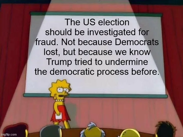 Lisa Simpson stands at a podium in front of a whiteboard in a classroom setting, delivering a serious message. The…