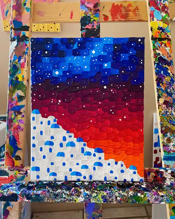 A thickly textured painting on canvas depicts a stylized sunset over white buildings with blue domes, resembling Santorini…