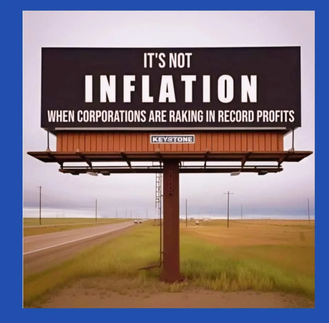 A large black billboard with white text stands beside a rural highway, displaying the message 'IT'S NOT INFLATION WHEN…