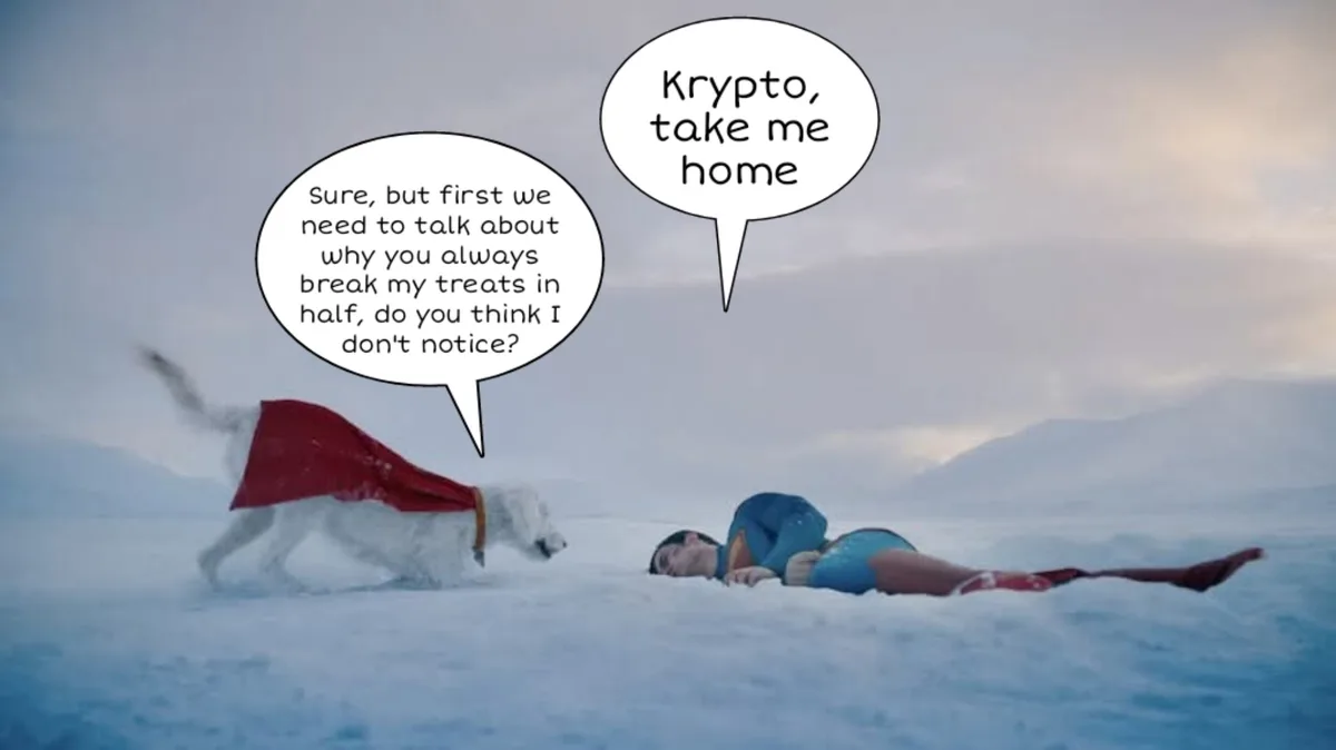 A white dog wearing a red cape stands over a person in a blue and red superhero costume lying in the snow. The dog's speech…