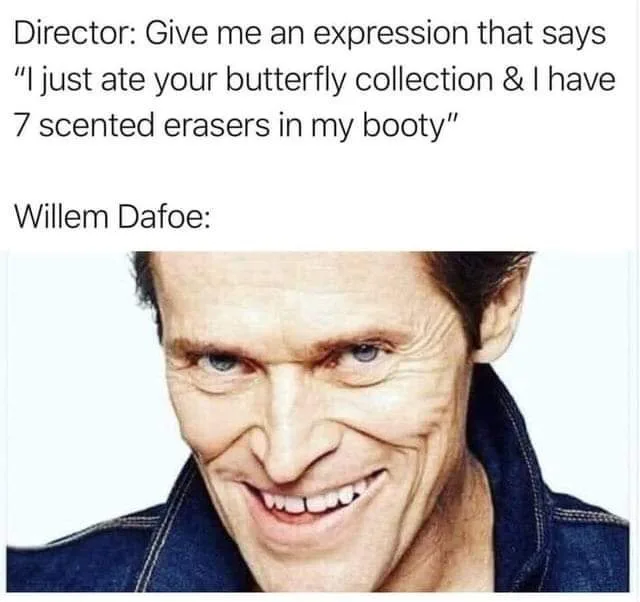 The image shows a close-up of actor Willem Dafoe with a wide, unsettling grin, his eyes narrowed and teeth showing. Above…