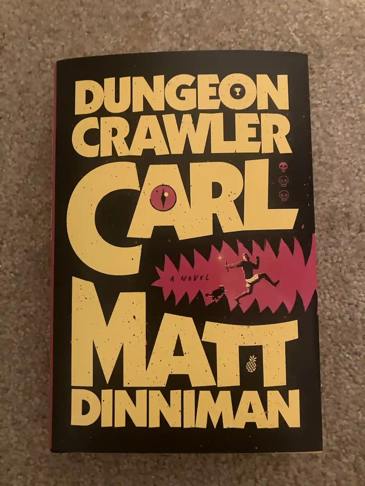 A book cover for 'Dungeon Crawler Carl' by Matt Dinniman, featuring bold yellow text on a black background. The title…