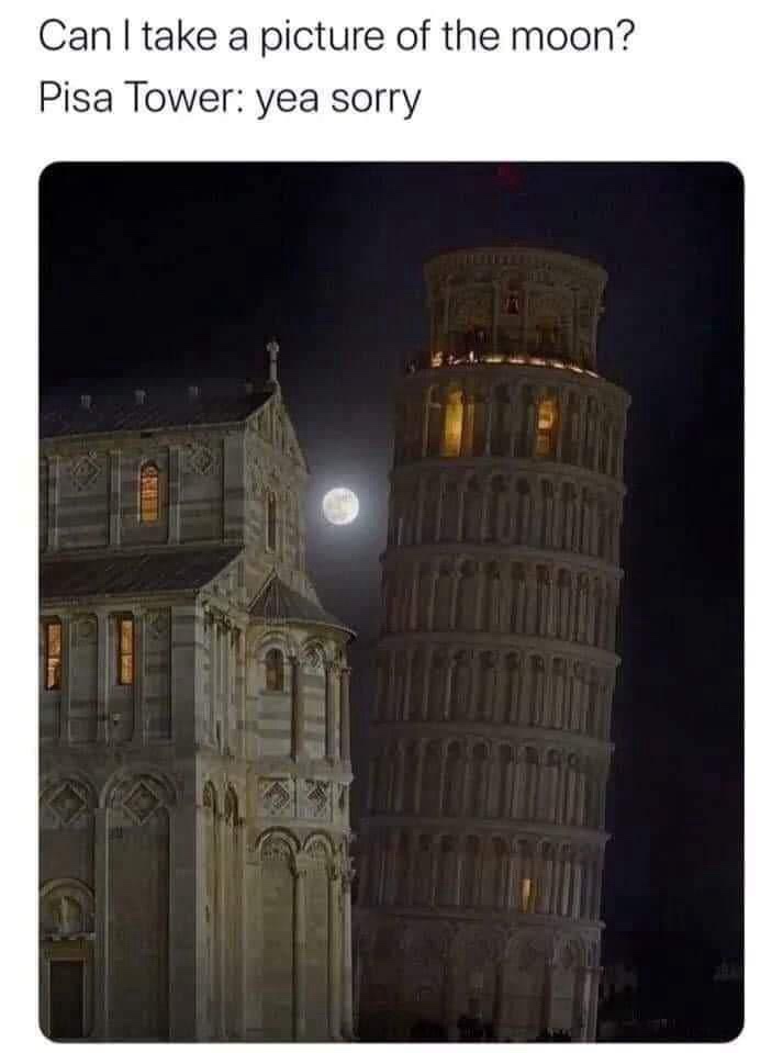 A nighttime photo shows the Leaning Tower of Pisa and a nearby building, with the full moon positioned directly behind the…