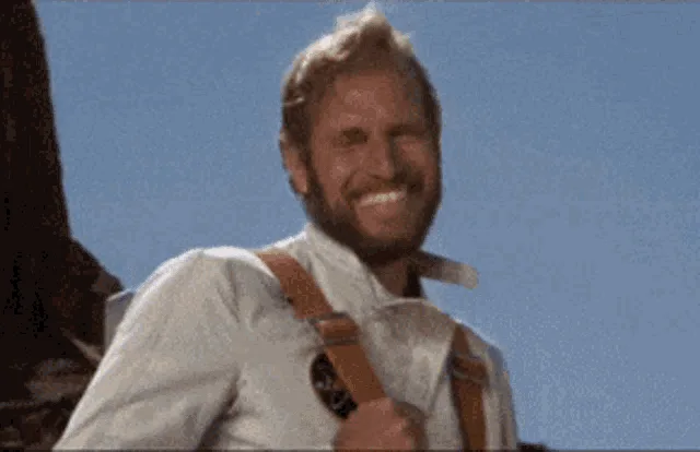 A sequence of five frames shows a man with a beard and light hair, wearing a white shirt and brown suspenders, against a…