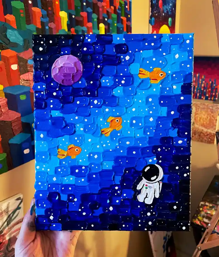 A hand holds up a textured, thickly painted canvas depicting a surreal scene: an astronaut in a white suit floats in a deep…