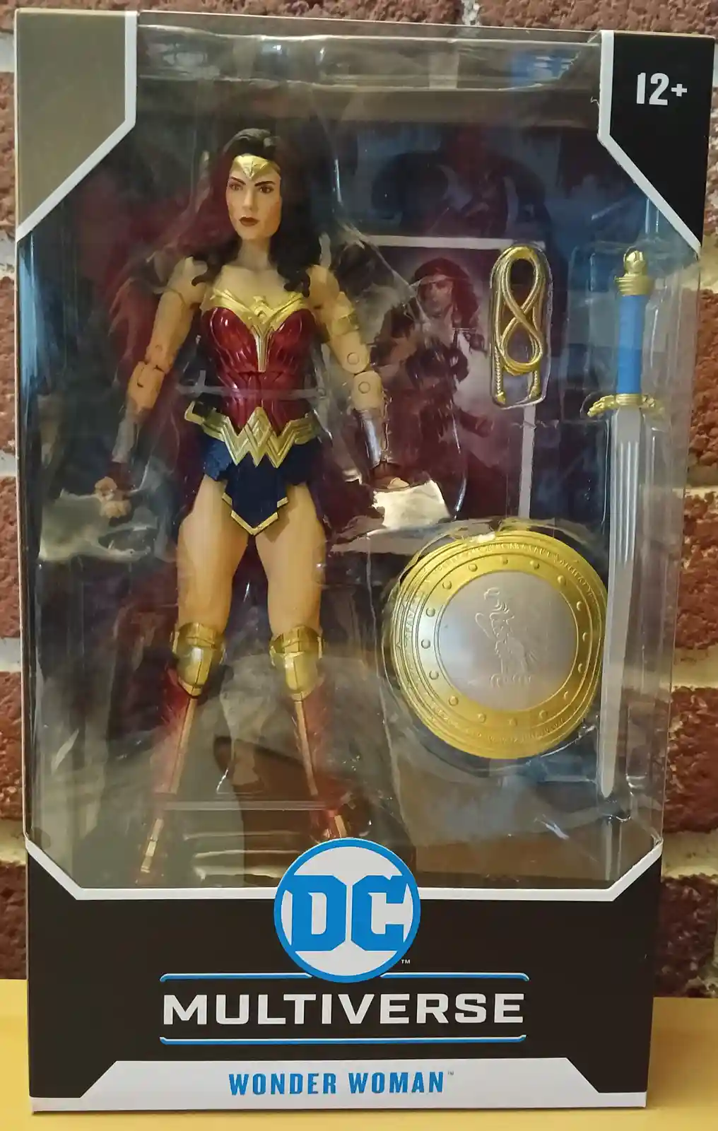 A DC Multiverse action figure of Wonder Woman in her classic red, blue, and gold costume, displayed in its original…