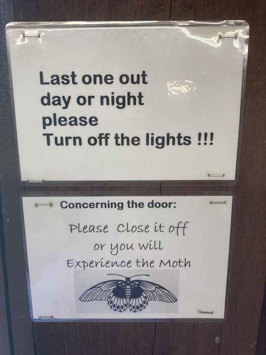 Two signs are taped to a wooden door. The top sign says 'Last one out day or night please Turn off the lights !!!'. The…